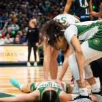 Storm players stand over their teammate after she was fouled onto the floor.
