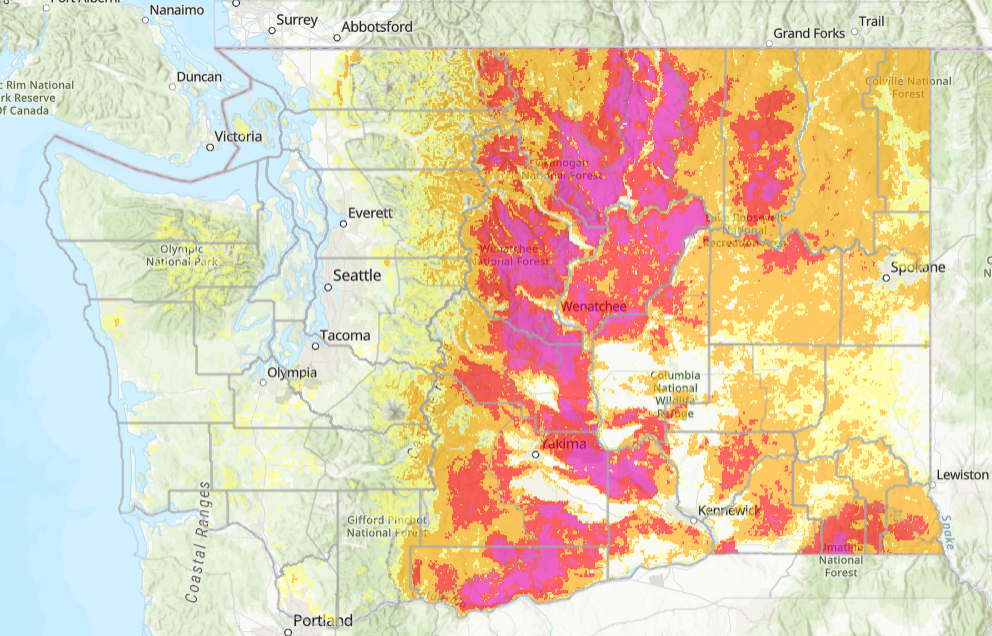 A topographical map showing a gradient of colors from yellow to red and pink, indicating varying levels of data across regions in Washington and parts of Idaho, with major cities like Seattle, Spokane, and Kennewick marked.